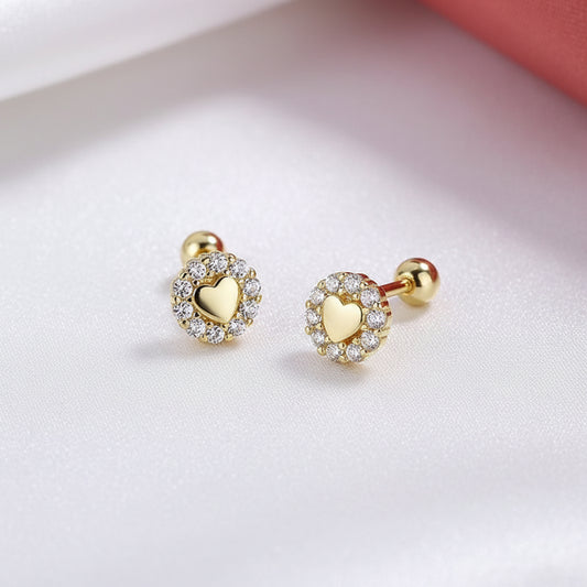 Tiny Gold Heart Halo Earrings with clear stones on a light pink background