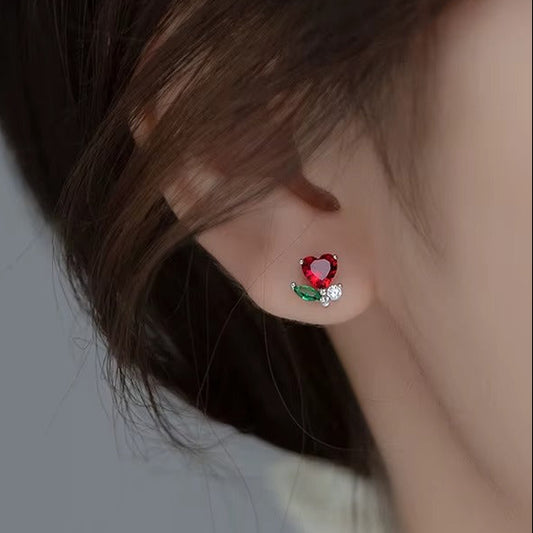 Close-up of an ear wearing a Mini Ruby Heart Blossom Earrings.