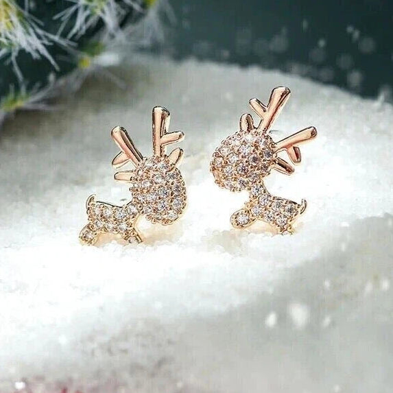 Gold Zircon Reindeer Earrings on a snowy background