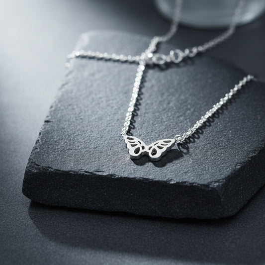 Silver Origami Butterfly Necklace displayed against a wooden background.