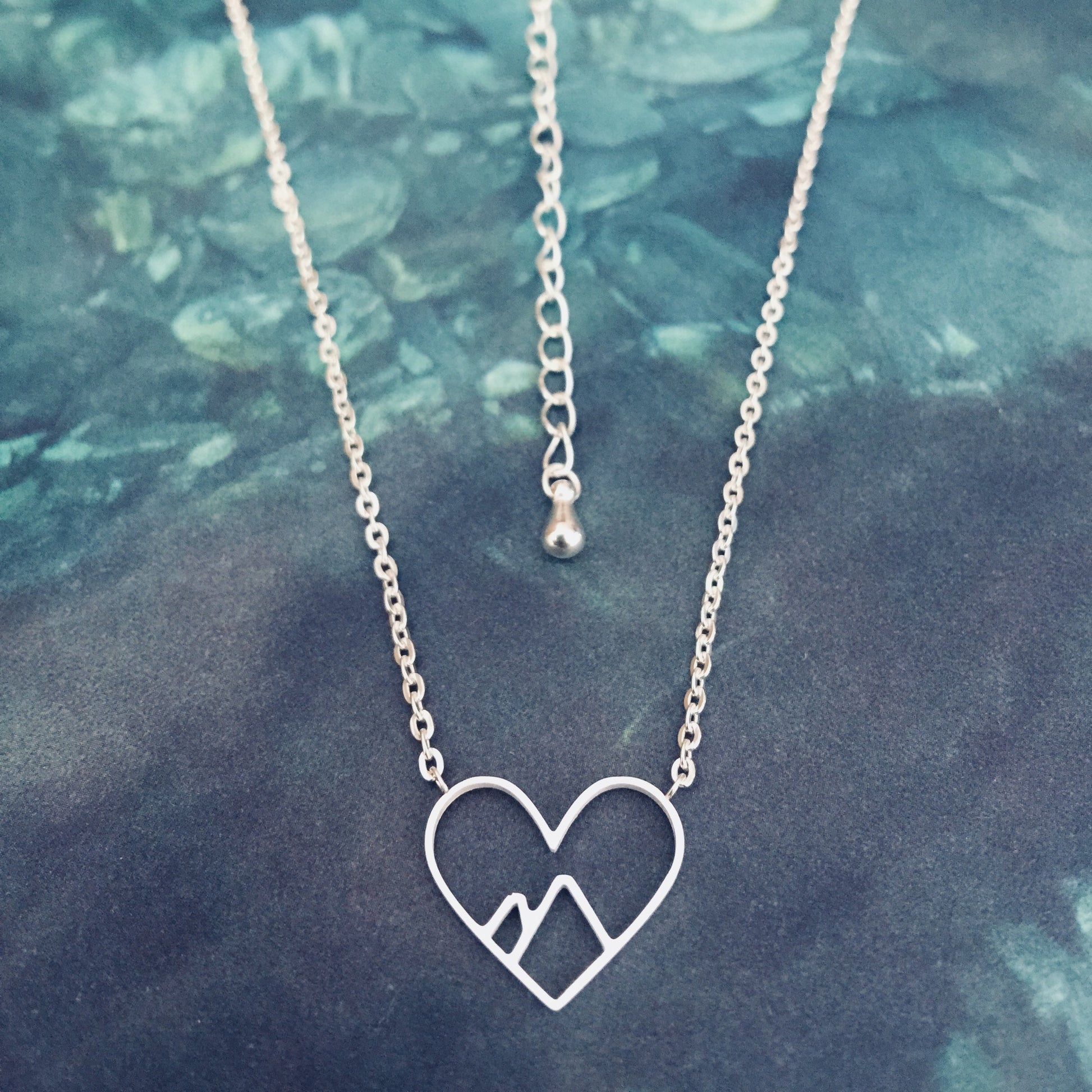 Silver stainless steel mountain heart necklace with a heart-shaped pendant and a chain.