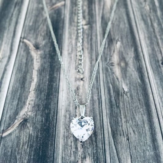 Adjustable silver necklace with a heart-shaped cubic zirconia pendant.
