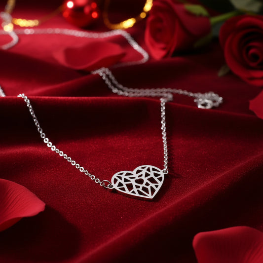 Origami Heart Necklace with a geometric heart pendant on a red fabric background