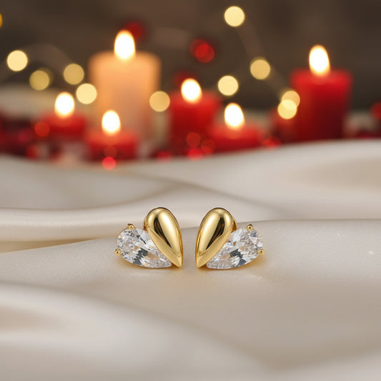 Gold Zircon Heart Earrings on white satin and red candles background