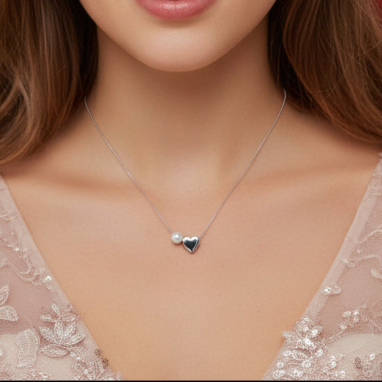 Silver Pearl Heart Necklace with a heart-shaped pendant worn by a model in a lace top.