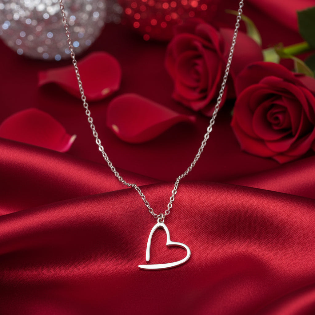 Silver Floating Heart Necklace on a red fabric background with red roses
