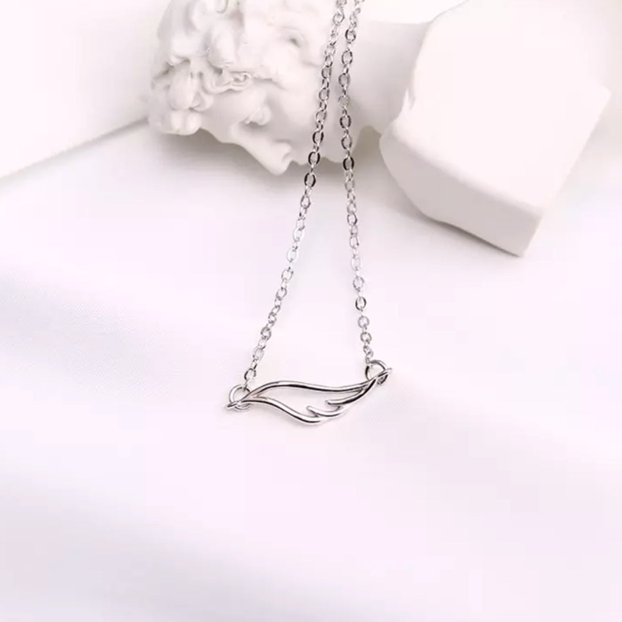 Angel Wing Necklace with a delicate pendant on a white background