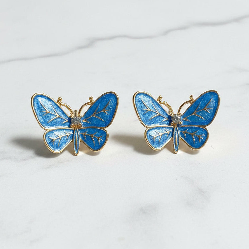 Blue Butterfly Statement Earrings on a white marble background