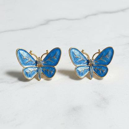 Blue Butterfly Statement Earrings on a white marble background