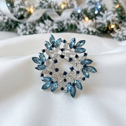 Blue Crystal Wreath Pin on white satin and Christmas scene