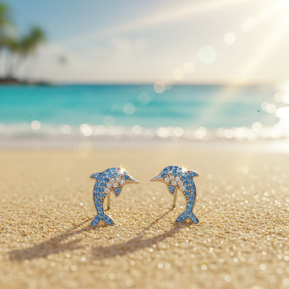 Blue Pavé Dolphin Earrings on a beach