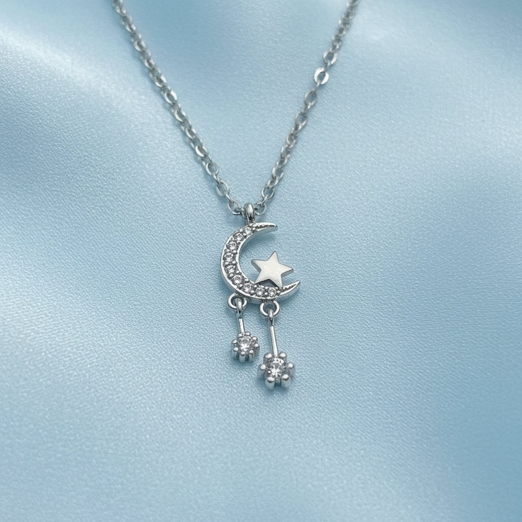 Silver Celestial Moon & Star Dangle Necklace on a light gray background