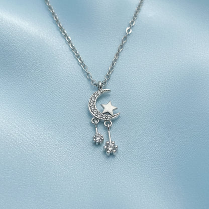 Silver Celestial Moon & Star Dangle Necklace on a light gray background