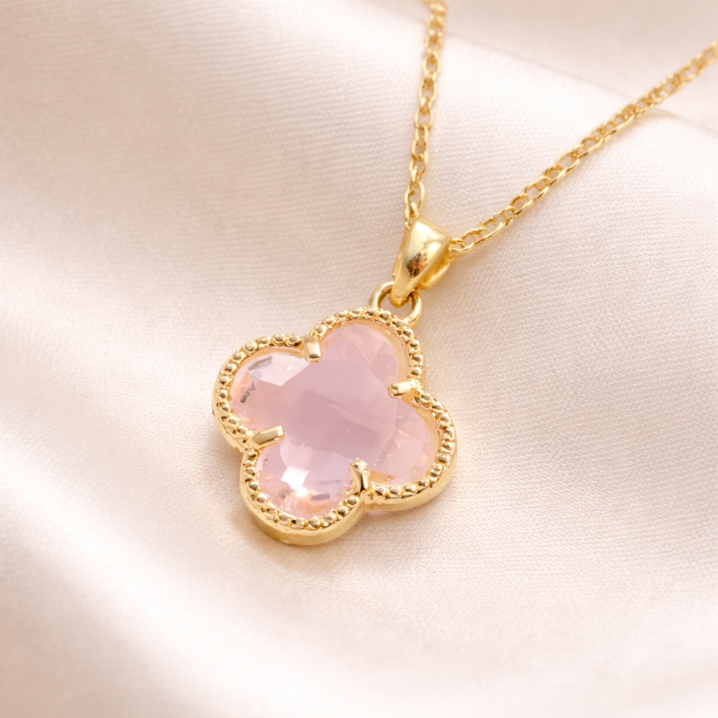 Pink Clover Gold Necklace with a pink clover-shaped pendant on a light pink background