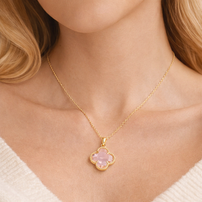 Pink Clover Gold Necklace with a pink clover pendant on a person wearing a white sweater.