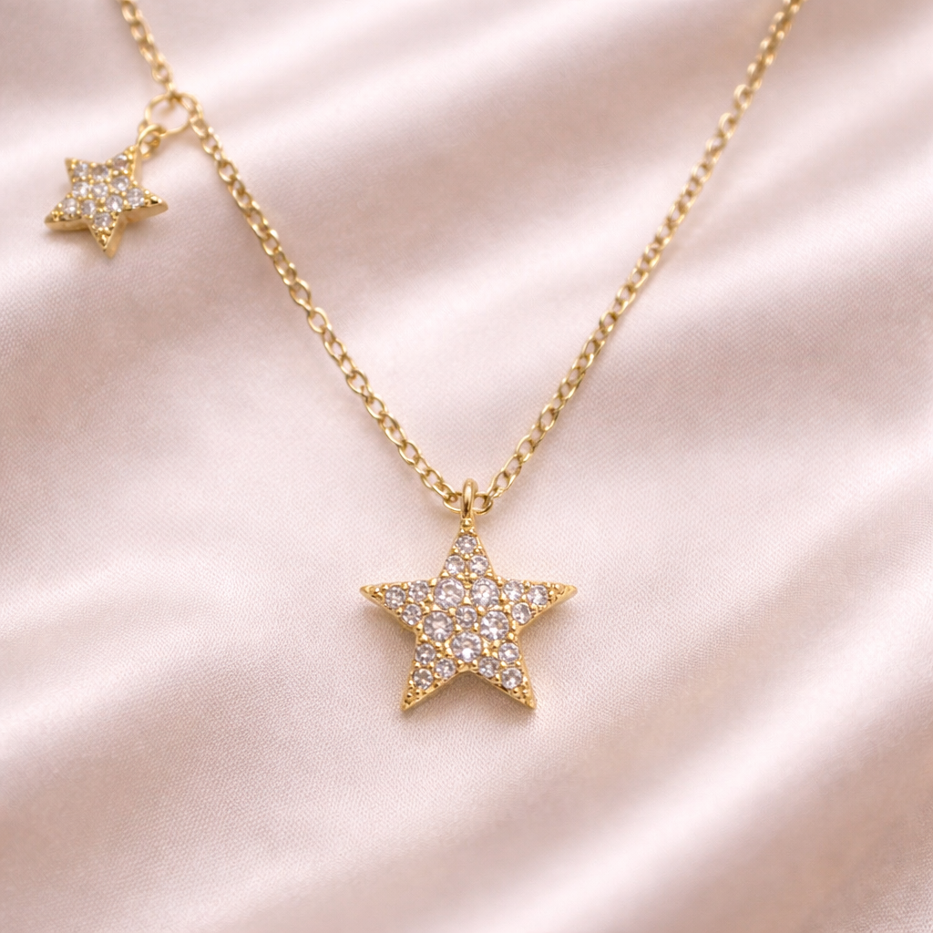 Gold Double Star Necklaceon a pink satin background