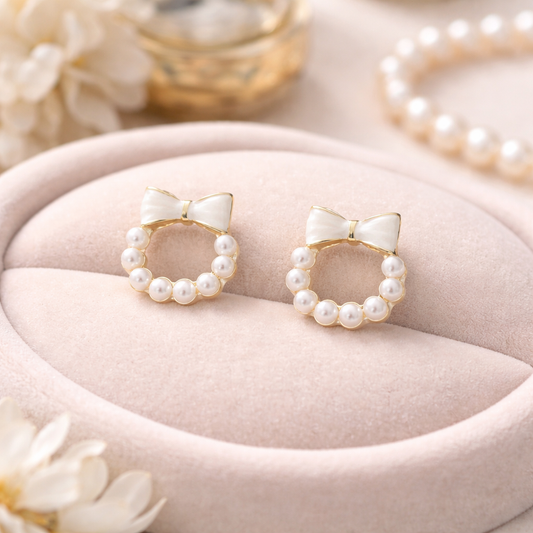 Ivory Bow Pearl Wreath Earrings on a pink jewelry cushion.