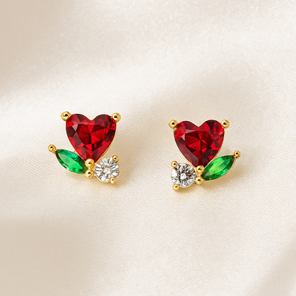 Mini Ruby Heart Blossom Earrings with red, green, and clear stones on a beige background