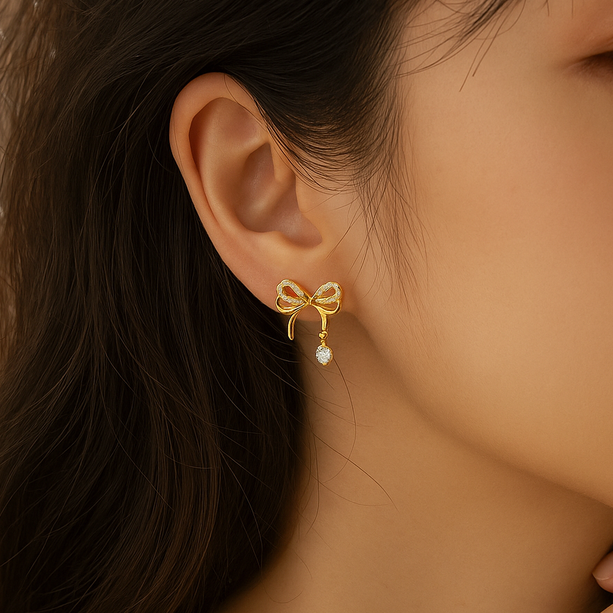 Sparkling Gold Crystal Bow Earrings worn by a person.