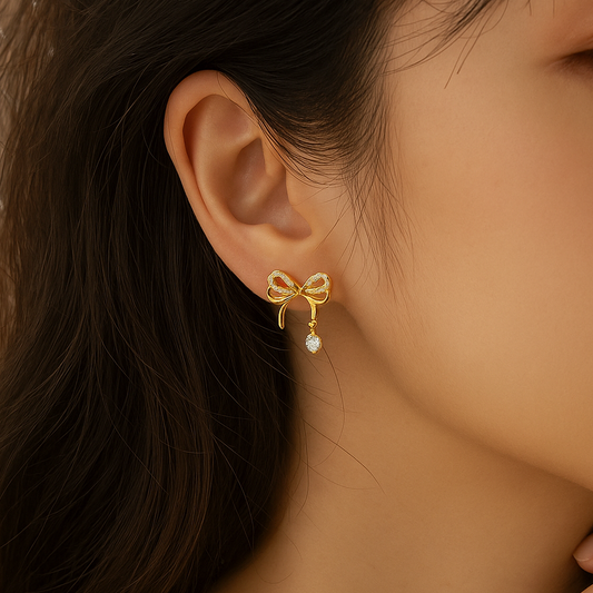 Sparkling Gold Crystal Bow Earrings worn by a person.