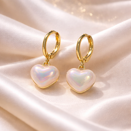 Iridescent Heart Drop Earrings with gold hoops on a soft fabric background