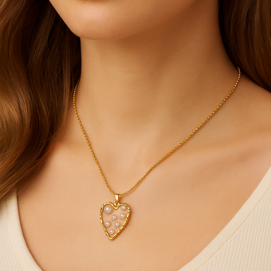 Close-up of a person wearing a Golden Heart Pearl Necklace with a heart-shaped pendant.