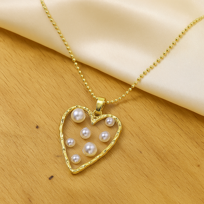 Golden Heart Pearl Necklace on a wooden surface
