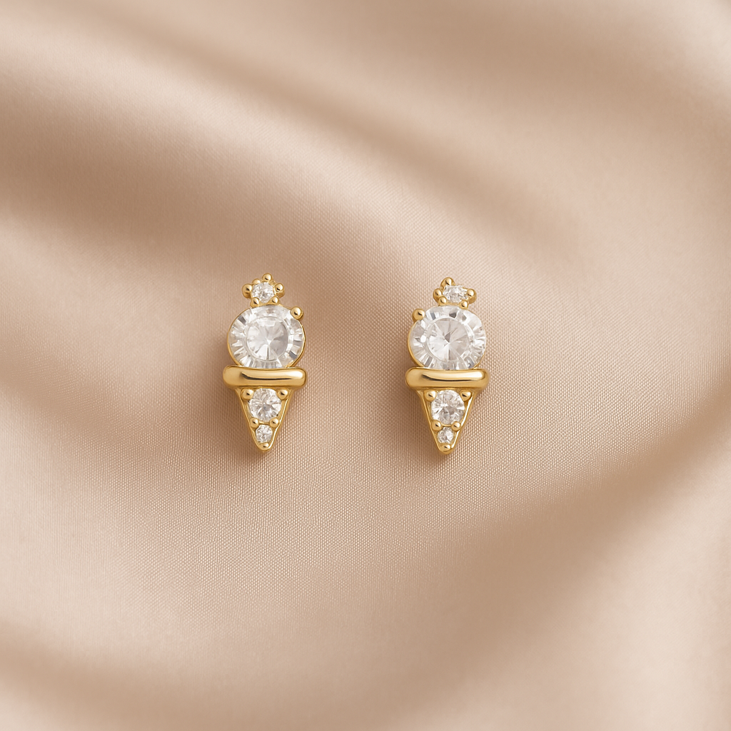 Mini Gold Ice Cream CZ Earrings with clear gemstones on a beige satin background