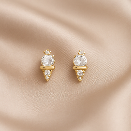 Mini Gold Ice Cream CZ Earrings with clear gemstones on a beige satin background