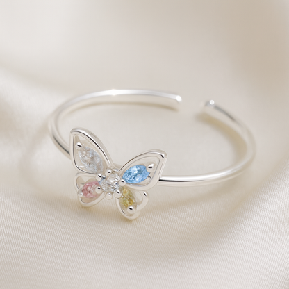 Pastel Butterfly Adjustable Ring on a satin background
