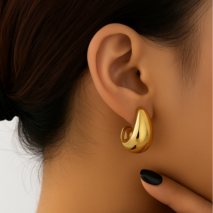 Gold Teardrop Hoop Earrings worn by a person with a neutral background