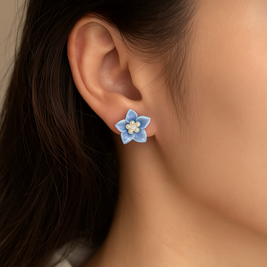 Close-up of an ear wearing a blue flower-shaped earring with a beige background