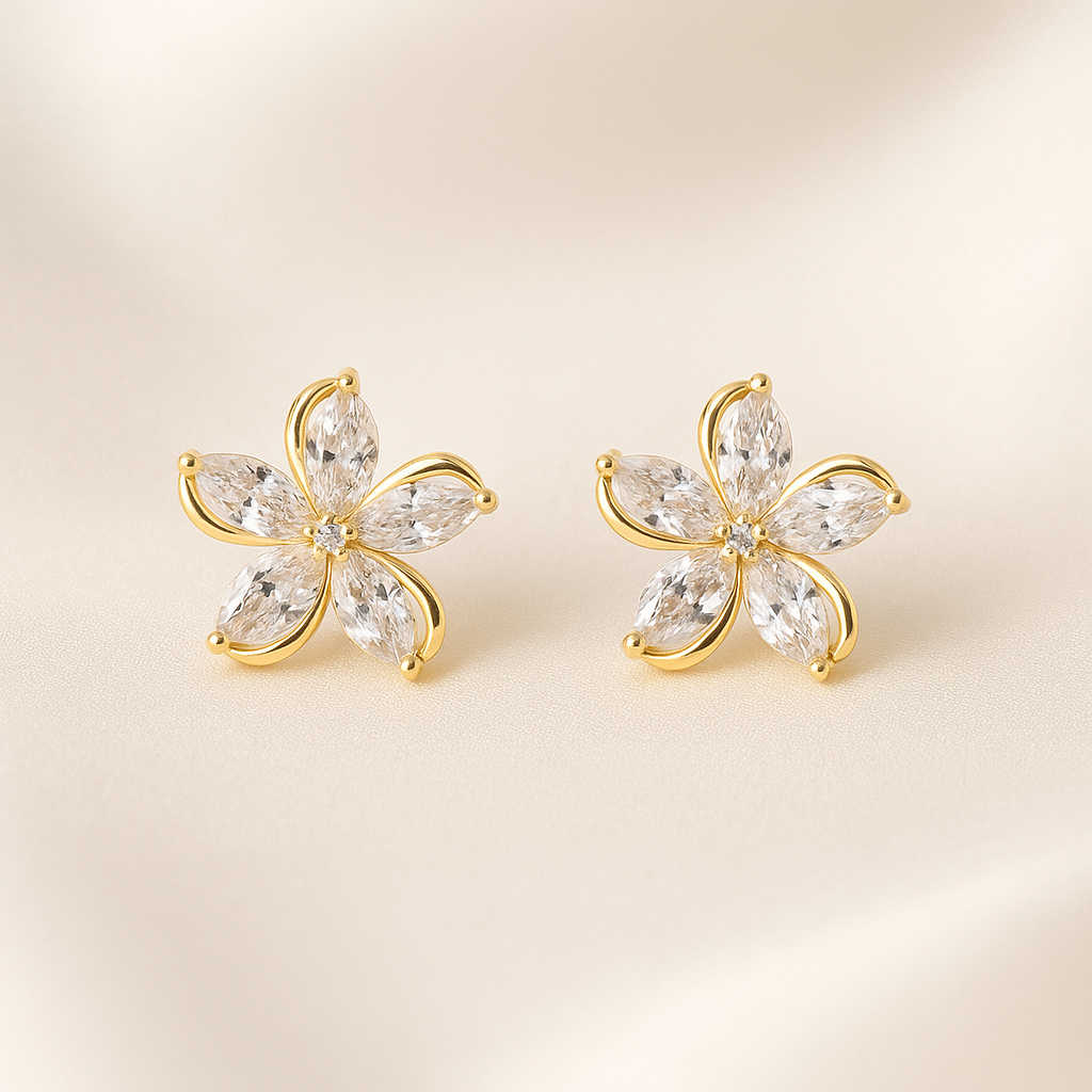 Gold Crystal Flower Earrings with clear gemstones on a beige background