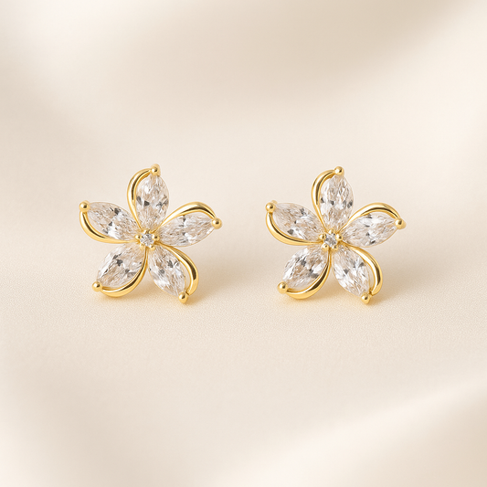 Gold Crystal Flower Earrings with clear gemstones on a beige background