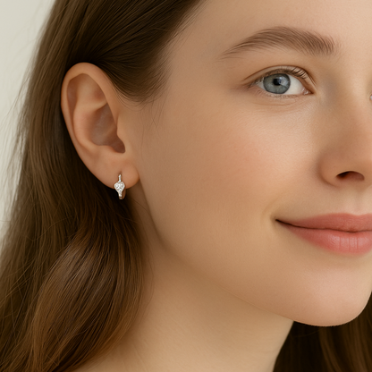 Close-up of a woman wearing a Silver Tiny Crystal Heart Earrings with a neutral background