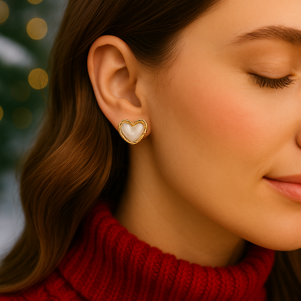 Close-up of a woman wearing Gold & White Opalescent Heart Earrings with a blurred background