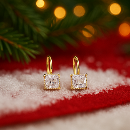 Classic Square Zircon Drop Earrings on a snowy surface with Christmas tree branches in the background.