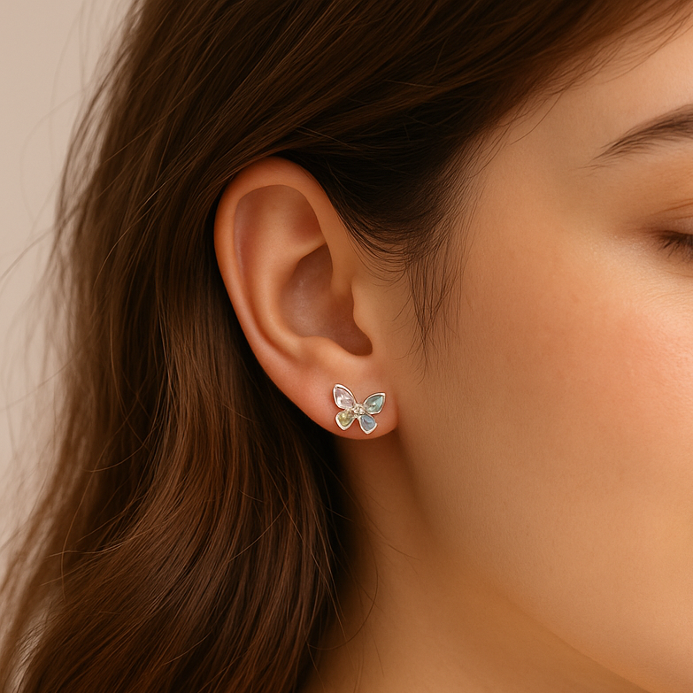 Close-up of a woman wearing Pastel Crystal Butterfly Earrings with a neutral background