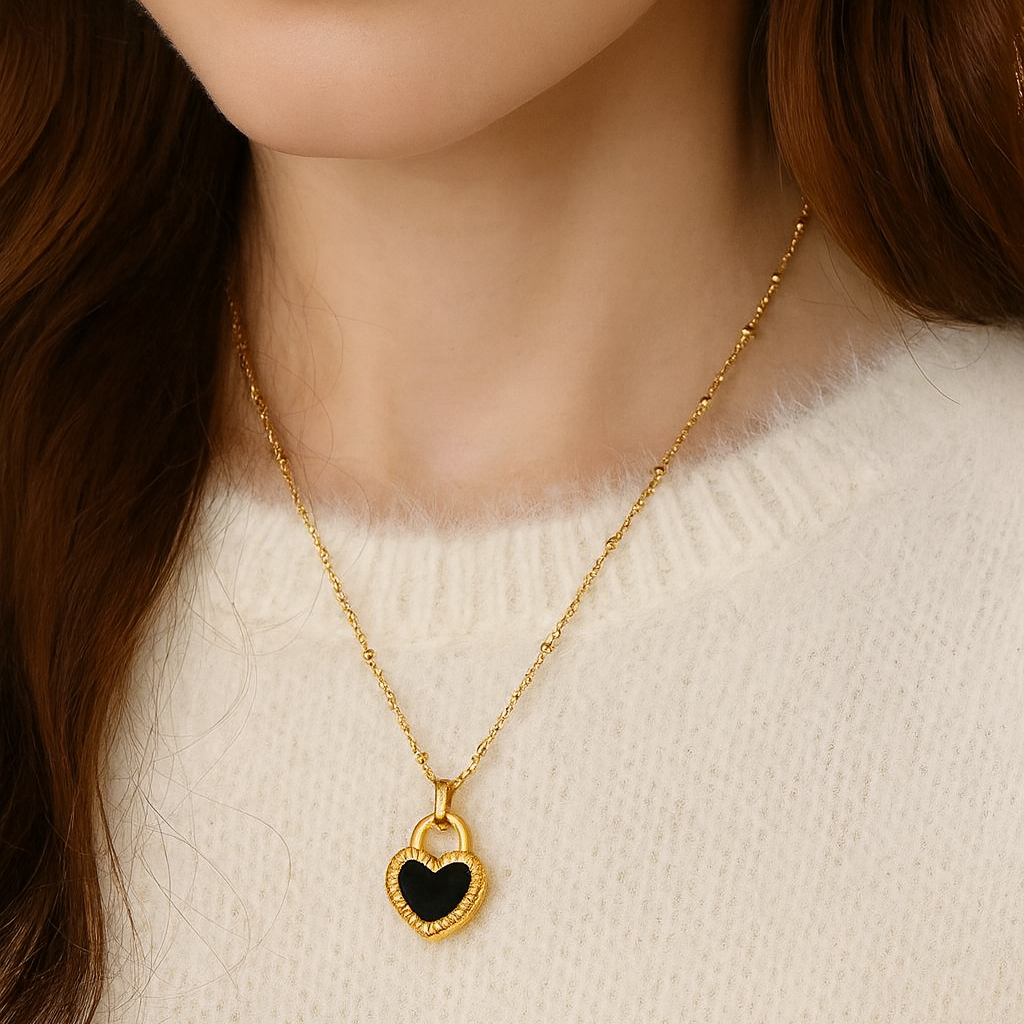 Black/White Reversible Gold Heart Necklace worn by a person against a neutral background