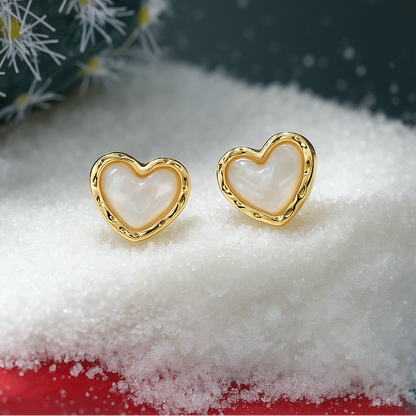 Gold & White Opalescent Heart Earrings on a snowy surface with a decorative box in the background.