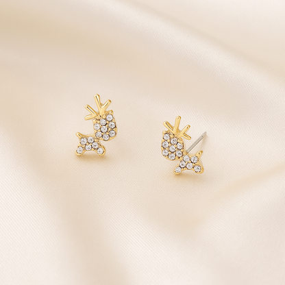Zircon Reindeer Earrings with clear gemstones on a beige satin background