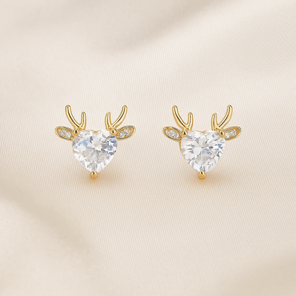 Gold Reindeer Zircon Heart Earrings with clear heart-shaped gemstones on a beige background