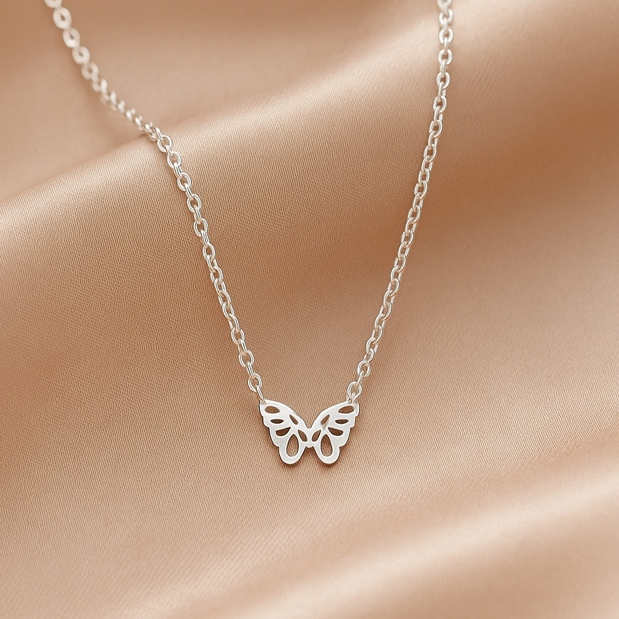 Silver Origami Butterfly Necklace on a soft pink fabric background