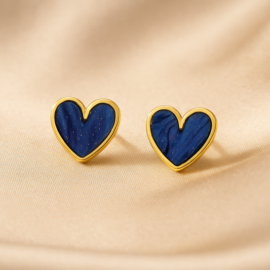 Blue Gold Dust Heart Earrings with blue centers and gold borders on a beige fabric background