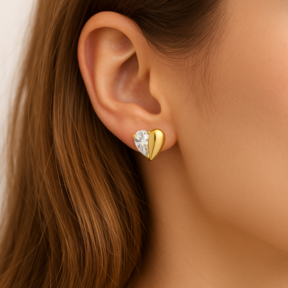 Close-up of a woman wearing a Gold Zircon Heart Earring with a clear gemstone.