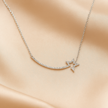 Delicate silver shooting star necklace with a star pendant on a soft beige fabric background