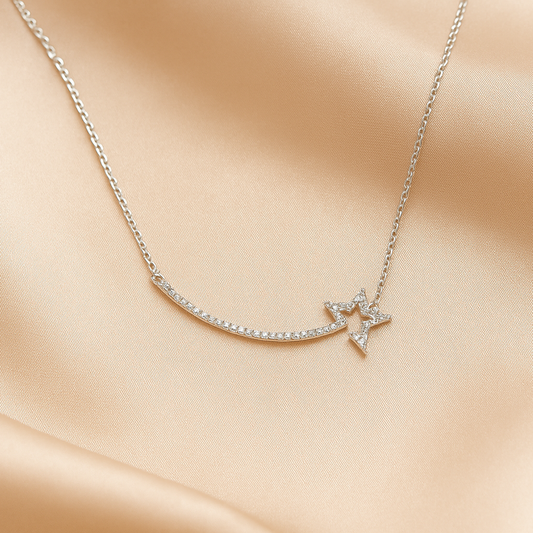 Delicate silver shooting star necklace with a star pendant on a soft beige fabric background