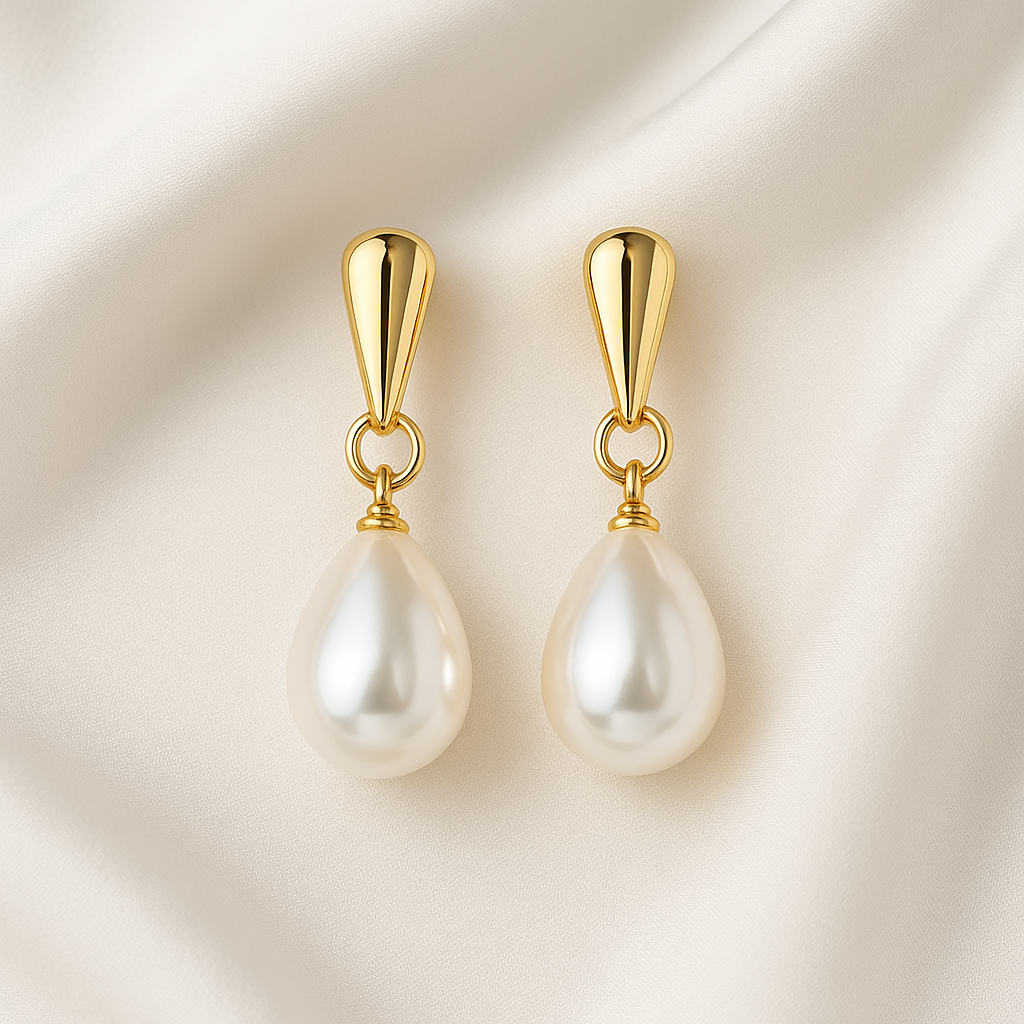 Gold Pearl Teardrop Earrings on a beige background