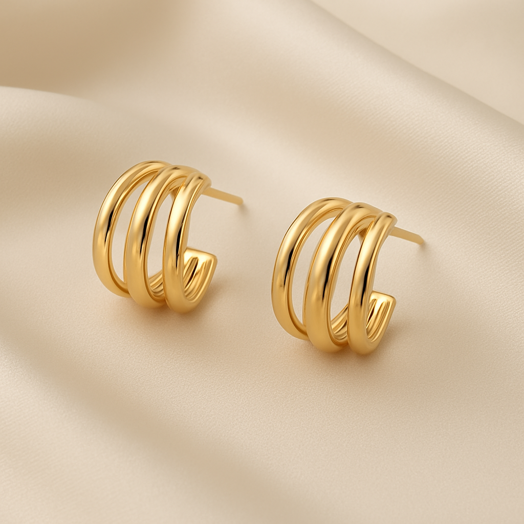 Triple Band Gold Hoop Earrings on a beige fabric background