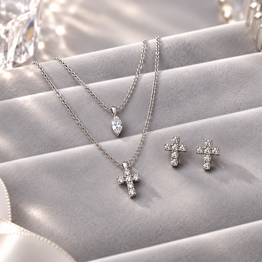 Sparkling Cross Earrings & Layered Cross Necklace Bundle jewelry set with a pendant necklace, matching cross stud earrings, and a small teardrop pendant, displayed on a gray velvet jewelry box.